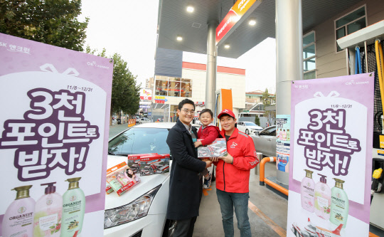 SK에너지 주유소 이용자가 OK캐쉬백 3000포인트 이벤트에 참여해 사은품을 받고 있다.<SK에너지 제공>